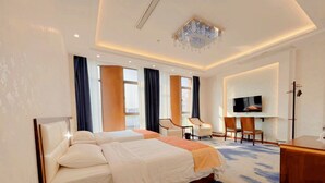 Ein Hotelzimmer mit einem großen Bett, einem Schreibtisch, einem Stuhl und einem Fernseher.