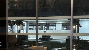 A reception area with a black reception desk labeled "STOREYS 1" and a leather sofa.