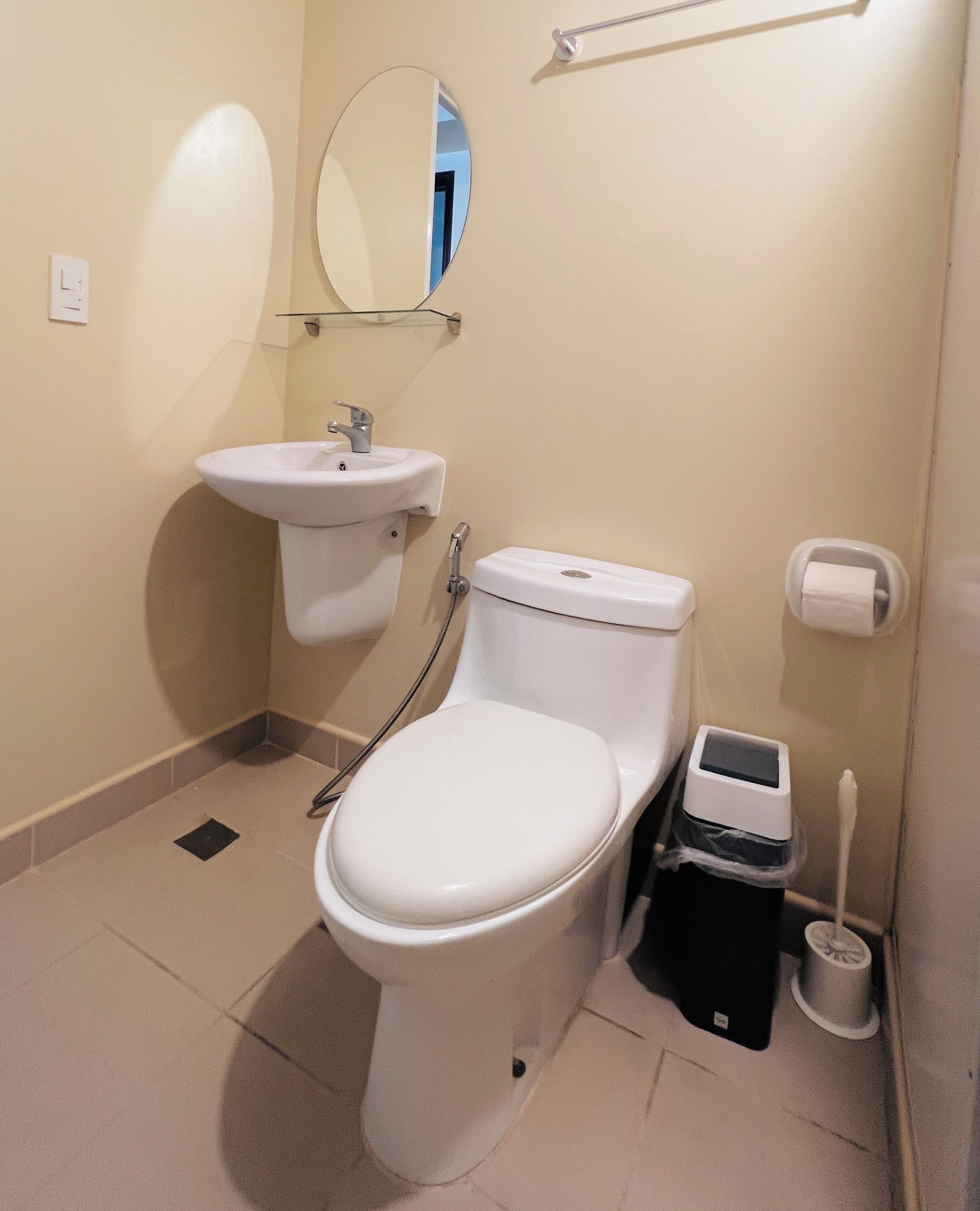 A standard bathroom with a toilet, sink, and hand dryer.
