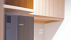 Una cocina moderna con un refrigerador Panasonic integrado, armarios de madera y una encimera blanca.
