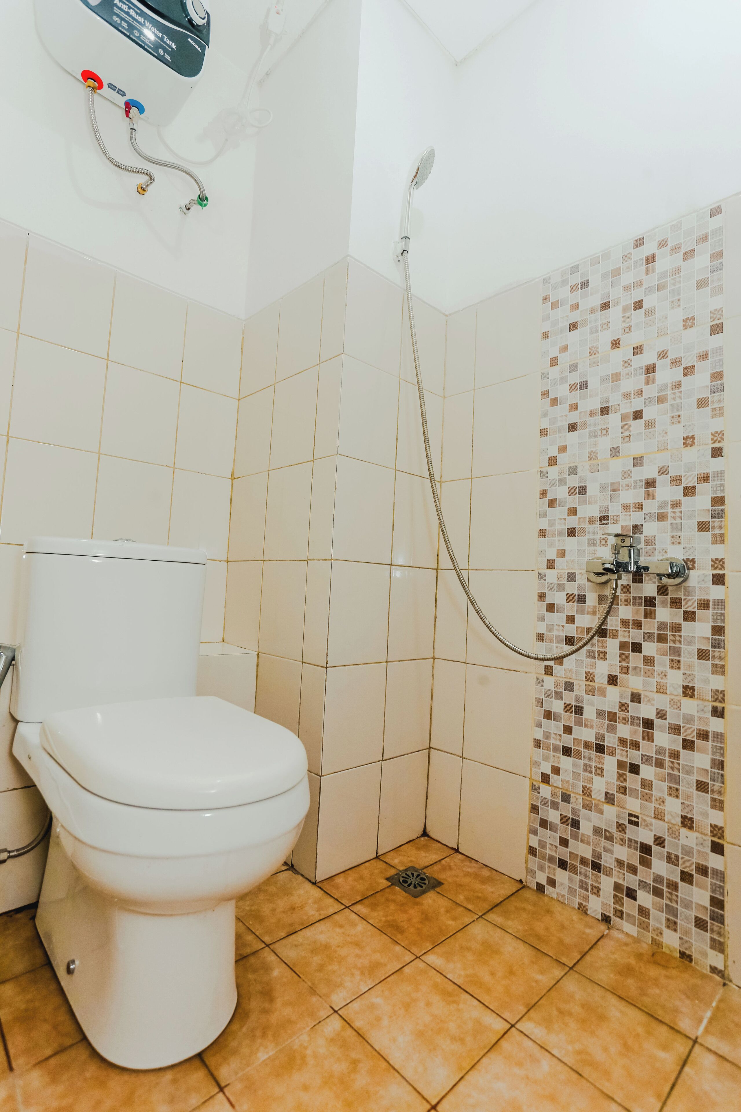A bathroom with a toilet, a shower, and tiled walls.