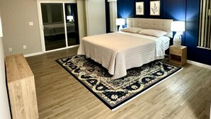 A bedroom with a bed, a ceiling fan, a large window, and a dark blue accent wall. - Newly remodeled 3 BR house, 5 min from WEC and by golf course. Dogs allowed (Ocala)