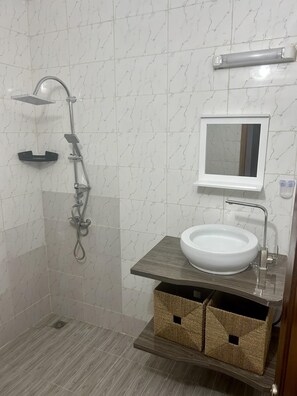 Enjoy a refreshing shower in this sleek bathroom with a walk-in shower and handheld showerhead.