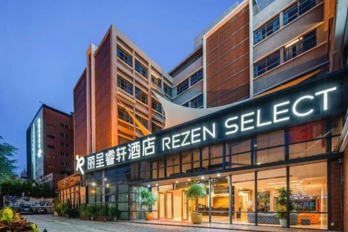 A hotel with a modern facade, large windows, and a sign that reads "REZEN SELECT".