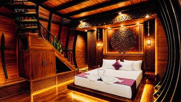 A wooden interior with a bed, staircase, and decorative wall panel.