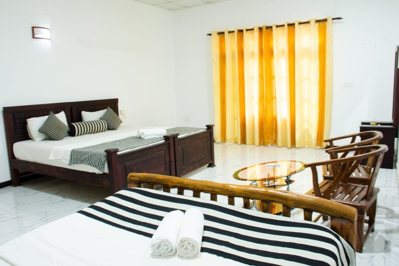 Une chambre d’hôtel avec un lit, une petite table ronde et deux chaises.