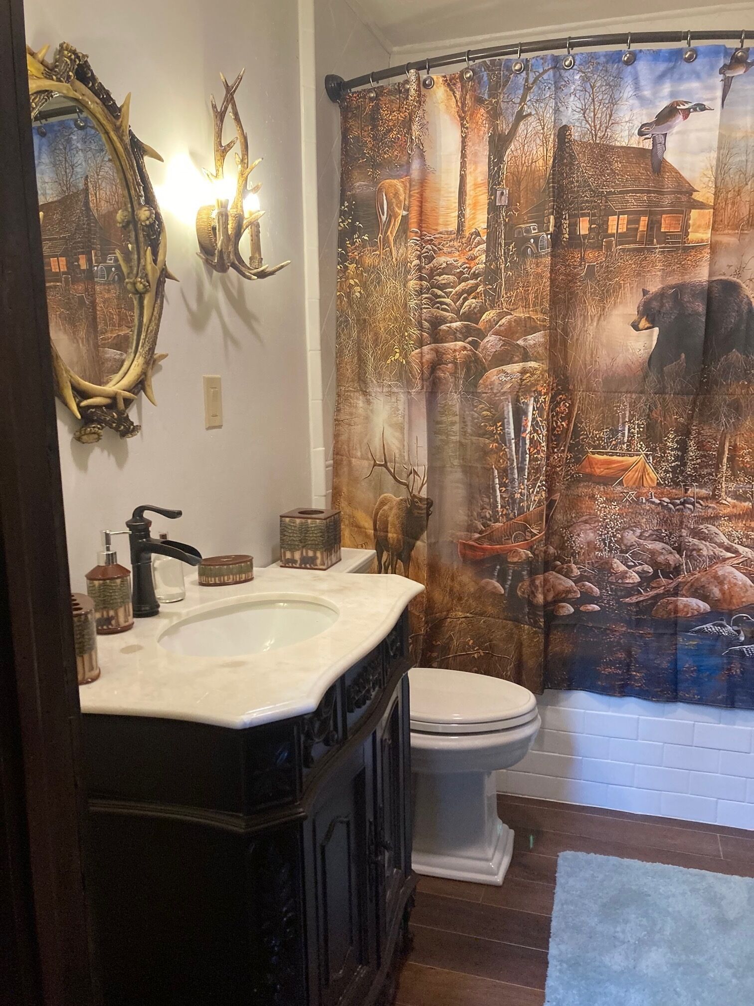 A bathroom with a large mirror, a sink, and a toilet.