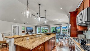 A modern kitchen with granite countertops, stainless steel appliances, and wooden cabinets.