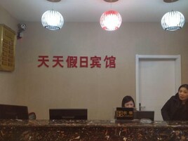 Un mostrador de recepción con un letrero, dos computadoras y una puerta al fondo.