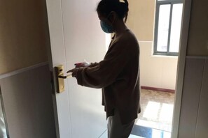 A person opening a door to a room with a window and a door handle. - Civil rights Holiday Inn (Minquan)