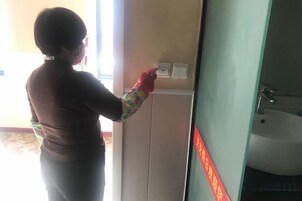 Una persona limpiando un lavamanos de baño.