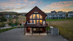 Ein modernes, zweistöckiges Haus mit Balkon, großen Fenstern und einer Garage.