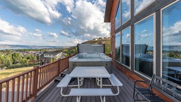 Eine Terrasse mit Whirlpool, Picknicktisch und Sitzgelegenheit mit Blick auf eine schöne Landschaft.
