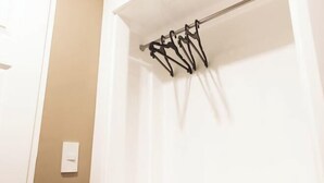 A white wall with a light switch and a metal rack with hooks. - Hotel Sogo Cainta (Cainta)