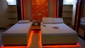A hotel room with two beds, a red-lit wall, and pendant lights. - Hotel Sogo Cainta (Cainta)