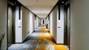 A long, narrow hotel corridor with a patterned carpet, white walls, and doors on both sides. - Wuxi Fengshe Boutique Hotel (Jiangnan University Taihu Scenery Belt Store) (Wuxi)