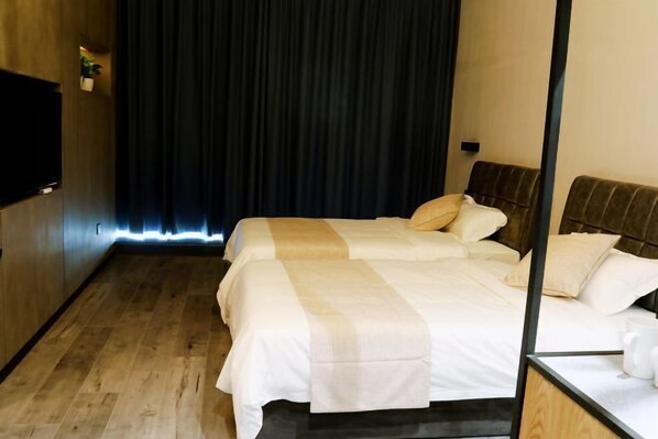 Quarto de hotel com cama, televisão e cortina escura.