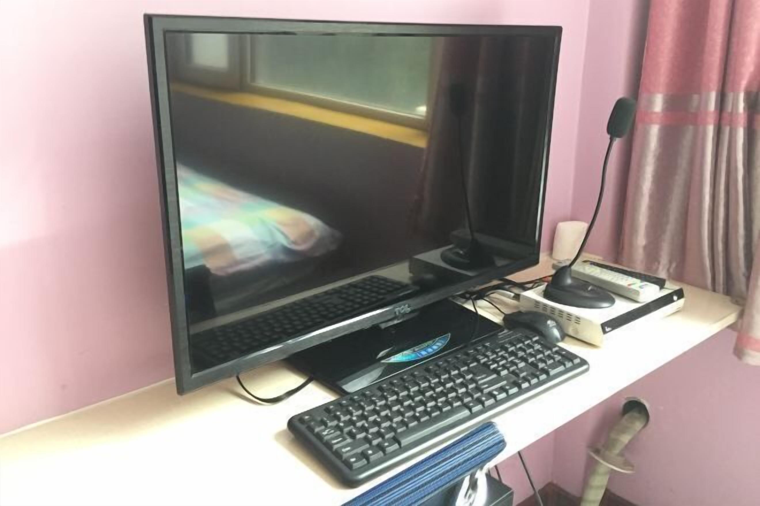 A computer setup with a monitor, keyboard, and mouse on a desk.