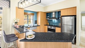 Eine moderne Küche mit einer Granitabdeckung, Edelstahlgeräten und Holzschränken.