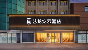 A hotel with a modern facade, large windows, and a prominent illuminated sign. - Yilong Anyun Hotel (Rudong Chahe Middle School) (Rudong)