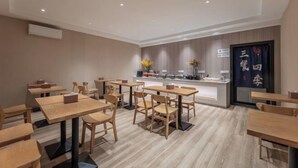 A restaurant with wooden tables and chairs, a counter with a menu, and a sign with Chinese characters. - Yilong Anyun Hotel (Rudong Chahe Middle School) (Rudong)