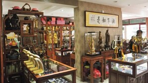 Ein traditioneller chinesischer Laden mit Holzvitrinen und Regalen, gefüllt mit verschiedenen Waren.