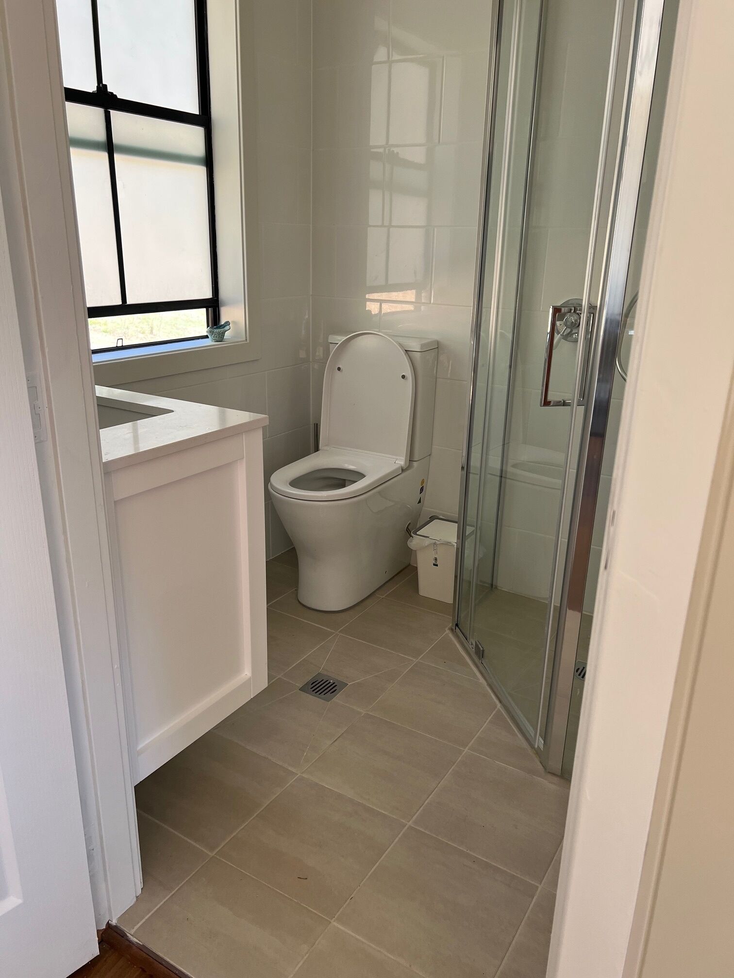 A bathroom with a toilet, a sink, and a shower area.