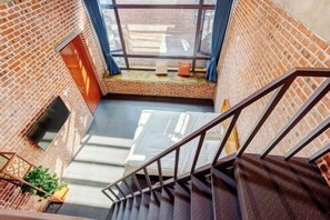 Eine Treppe führt zu einer Dachterrasse mit Blick auf die Stadt.