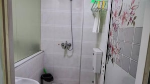Un baño pequeño con inodoro, ducha y lavamanos.