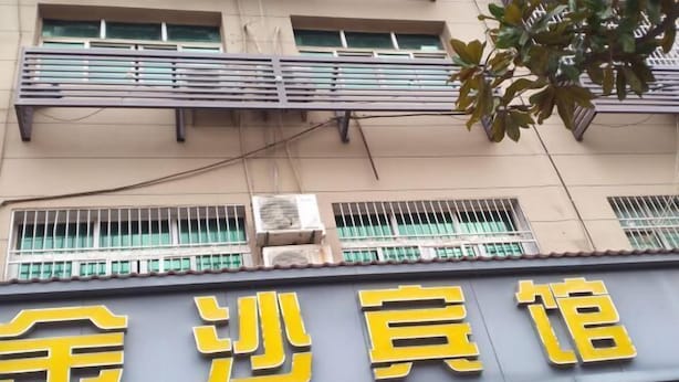 Un edificio con un letrero que dice "金沙宾馆" (Jinsha Inn).