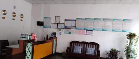 A reception area with a reception desk, a sofa, and informational posters on the wall.