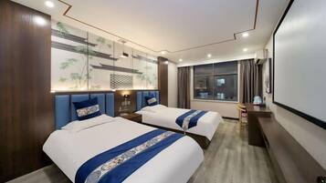 A hotel room with two beds, a large window, a wall-mounted TV, and a ceiling with recessed lighting.