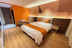 Quarto de hotel moderno com uma cama grande, uma escrivaninha e uma cadeira.