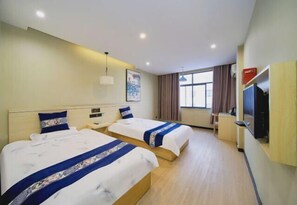 A hotel room with two beds, a TV, a desk, and a window with curtains. - Ningling Yijia Boutique Hotel (Ningling)