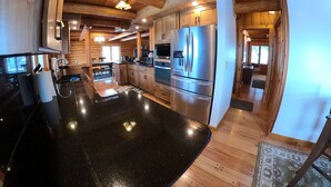Una cocina moderna con vigas de madera, electrodomésticos de acero inoxidable y una encimera de granito negro.