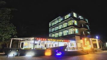 A multi-story building with illuminated signage and a covered entrance area.