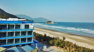 A beachfront hotel with multiple balconies overlooking the ocean.