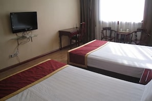 Une chambre dâhĂŽtel avec deux lits, une tĂ©lĂ©vision, un bureau et une chaise.