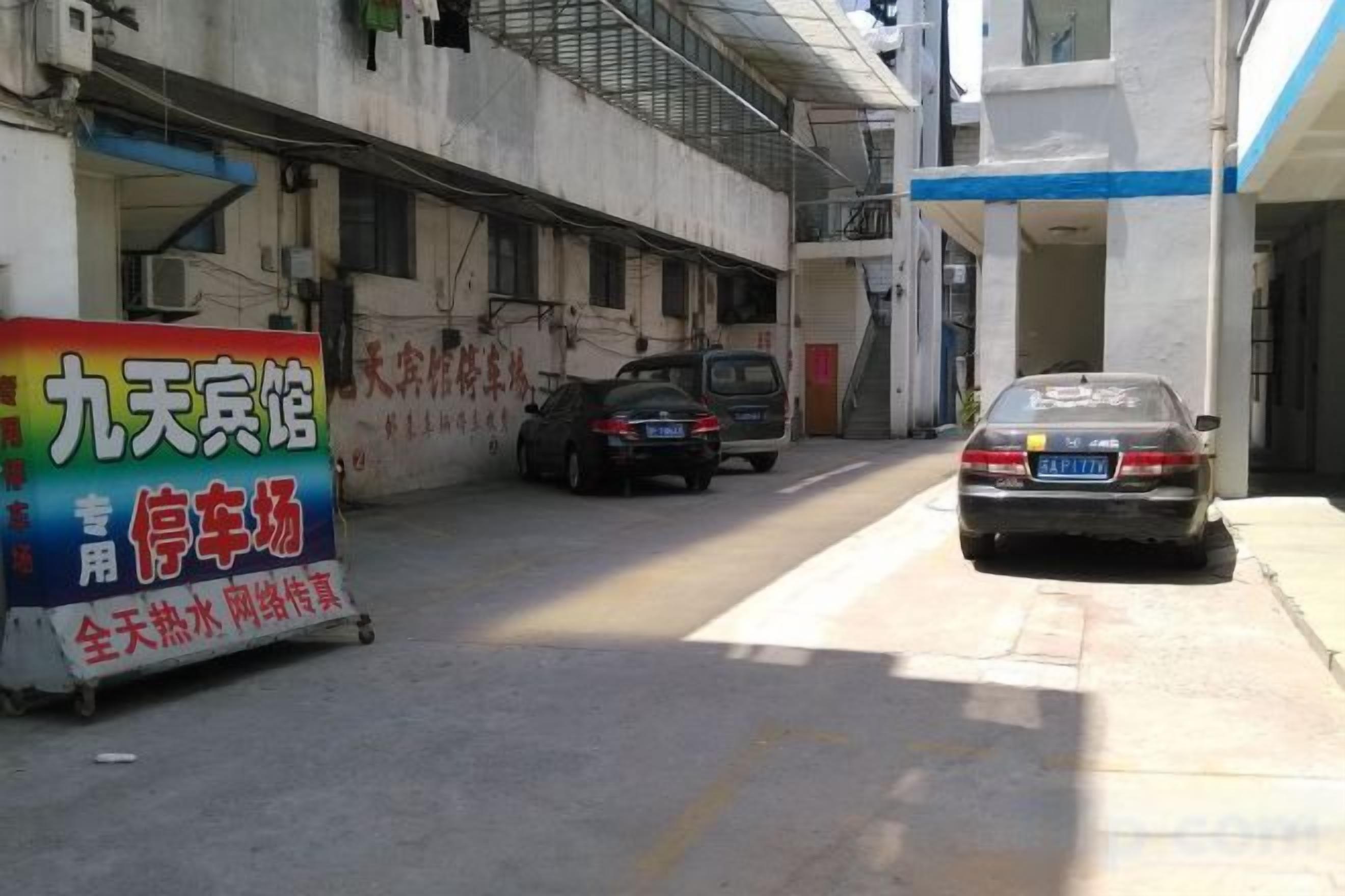 Un estacionamiento con un coche y un cartel.