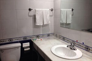Un baño con inodoro, lavamanos y barra para toallas.