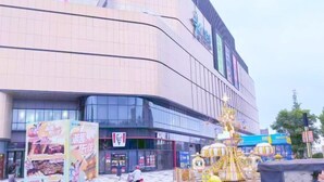 Een modern gebouw met een golvende gevel, grote glasramen en een opvallend KFC-bord.