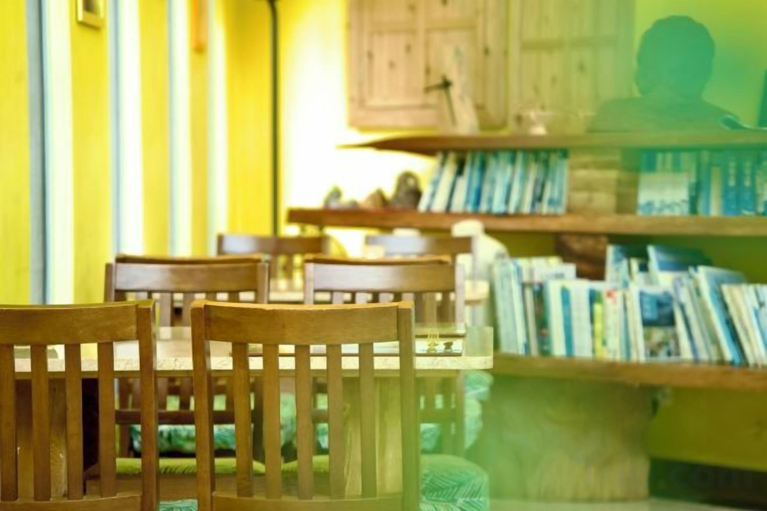 A library with bookshelves and wooden chairs.