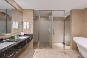 A modern bathroom with a glass shower enclosure, a white bathtub, and a marble vanity with two sinks. - New Century Hotel (Tongxiang)