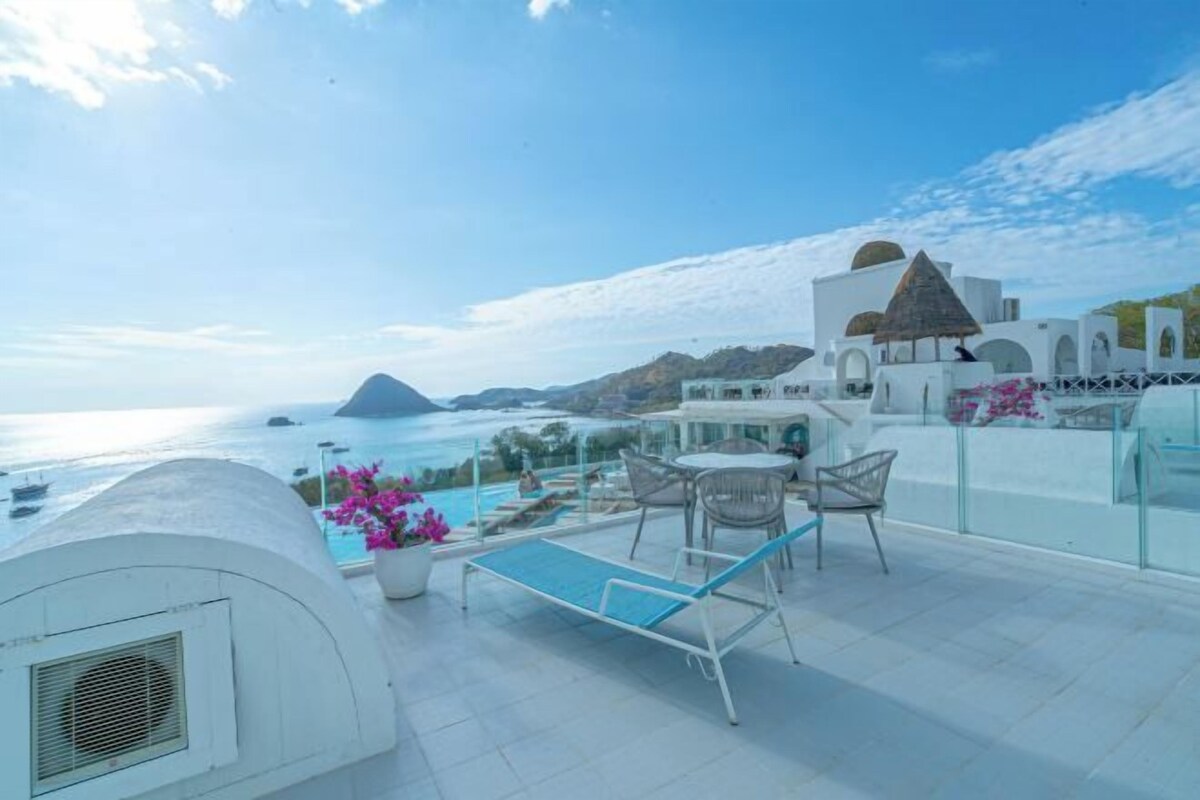 Une terrasse sur le toit avec une piscine, des chaises longues et une vue sur la mer.