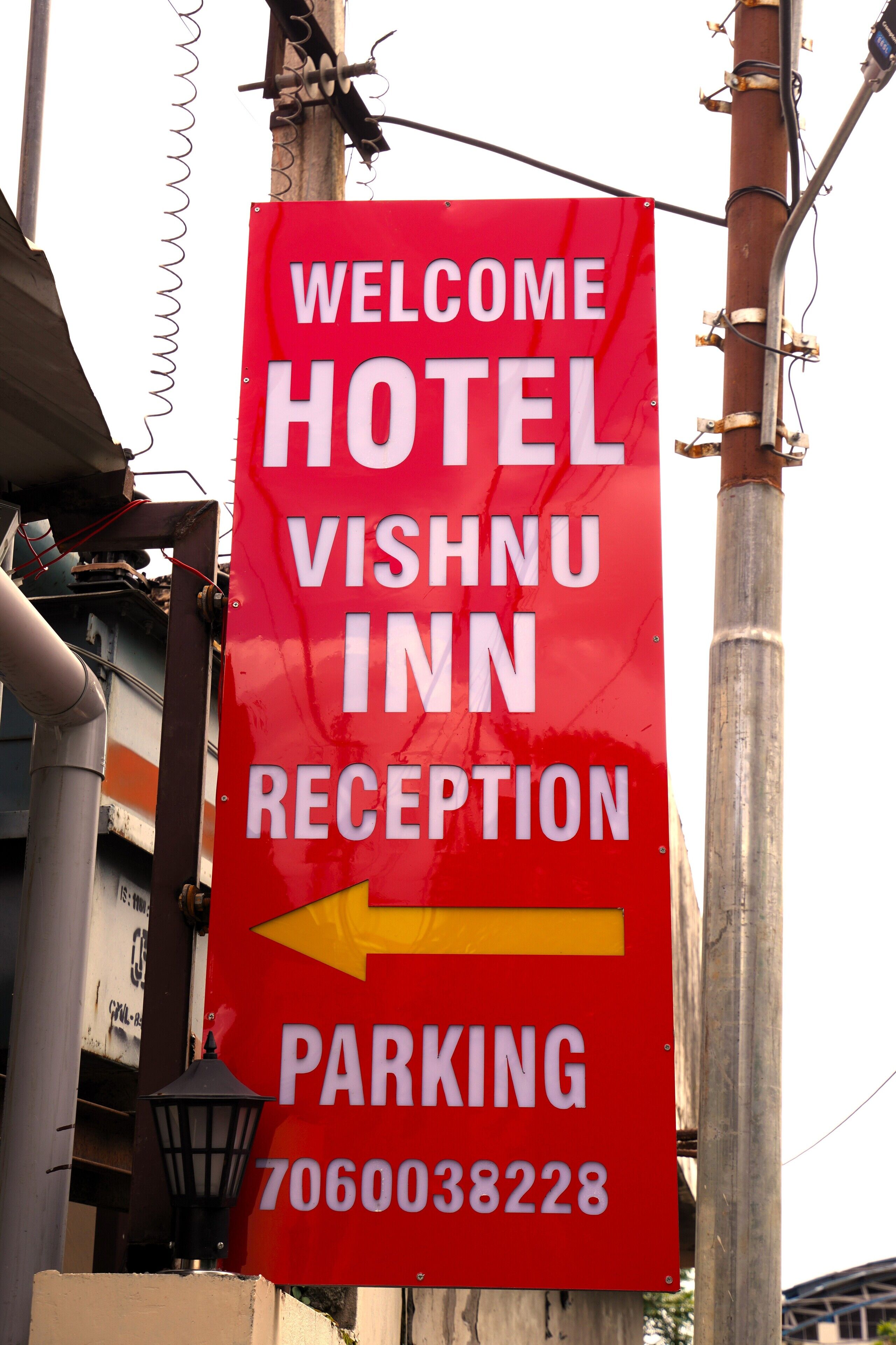 Ein rotes Schild mit weißer Schrift, das den Weg zur Hotelrezeption und zum Parkplatz weist.