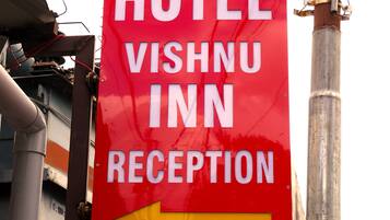 A red sign with white text indicating the direction to the hotel reception and parking.