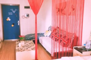 A room with a bed, a small table, and a door labeled 'Warm Home'.