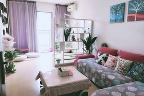 A modern living room with a sofa, a coffee table, and a bookshelf.