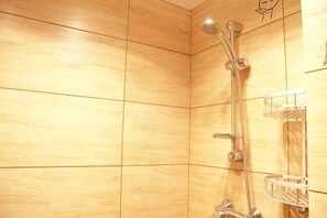 Eine Dusche mit Duschkopf und Wandarmatur.