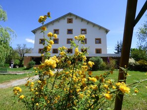 A white building with multiple windows and a central entrance. - Logis Hotel La Cremaillere St Bonnet (Saint-Bonnet-en-Champsaur)